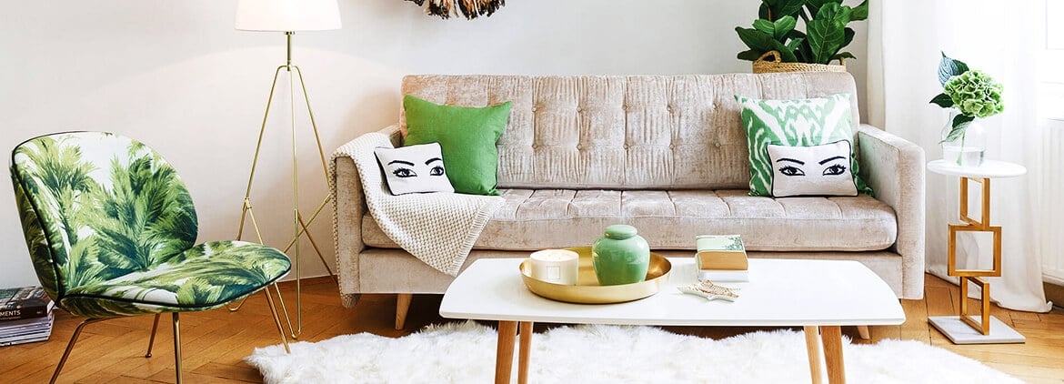 ein helles Sofa mit einem grünen Stuhl