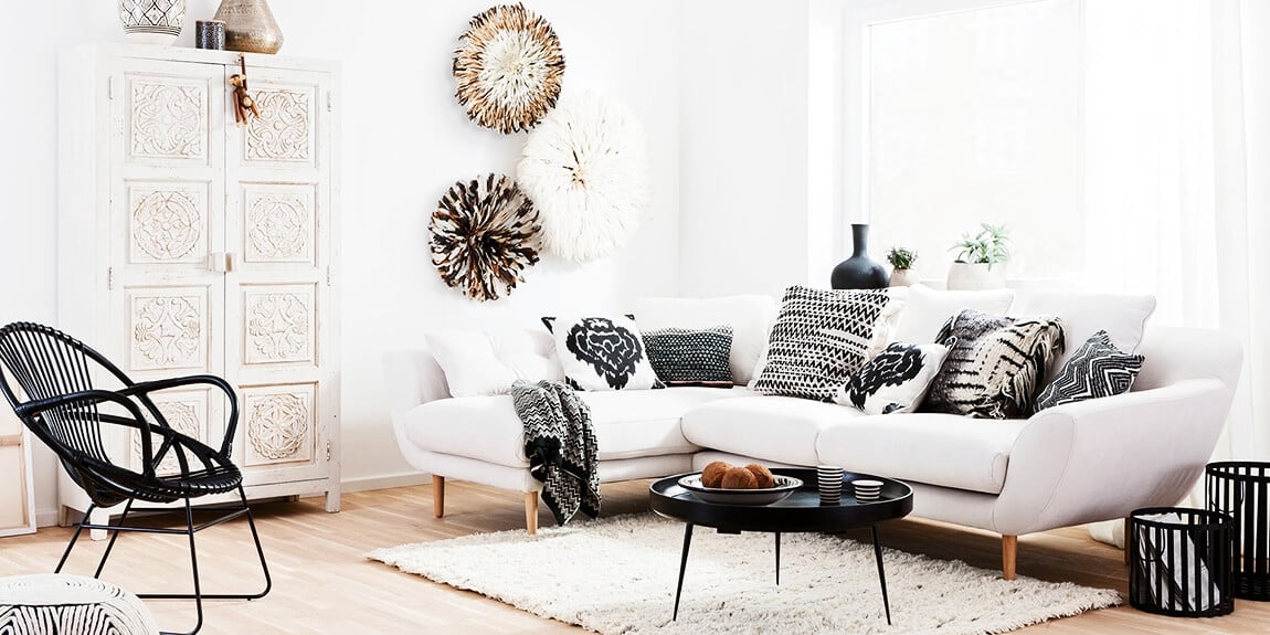 ein helles Sofa mit einem grünen Stuhl
