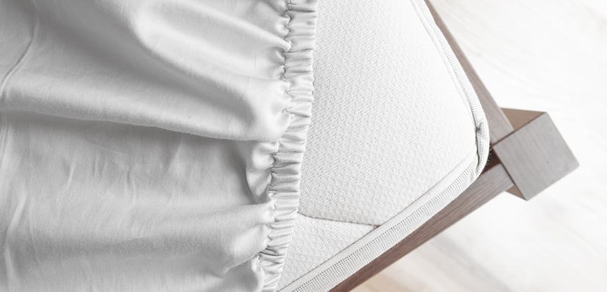 Ein grell rosafarbenes Sofa steht vor einer grauen Wand