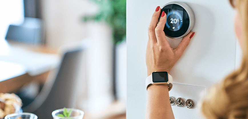 Frau bringt modernen Thermostat an