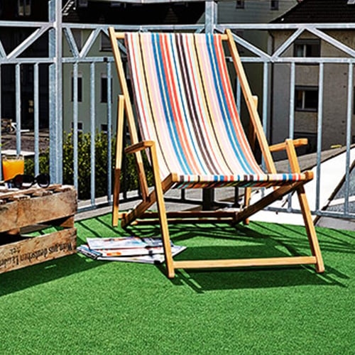 Zwei runde Couchtische in unterschiedlichen Höhen mit ovalen Füßen aus dunklem Marmor und Tischplatten Nussbaumholz stehen vor einem modernen, voluminösen, roten Sofa 