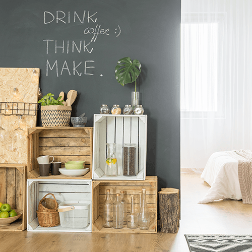 Ein Zimmer mit Holzkästen und einem Bett.