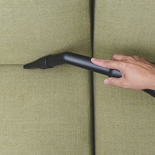 Ein runder, filigraner, schwarzer Couchtisch aus Metall auf einem schwarz-weißen Teppich