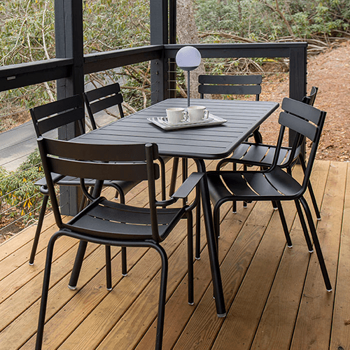 Eine schwarze Outdoor-Esstischgruppe aus Alu auf einer Holzterrasse