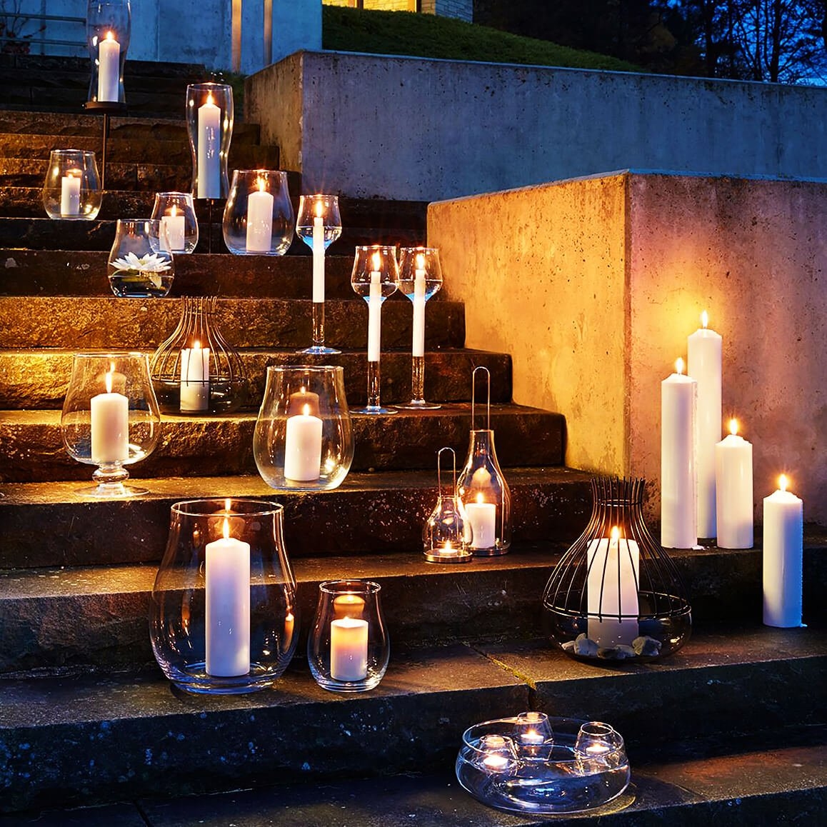 Mehrere Windlichter und Kerzen auf einer Treppe arrangiert