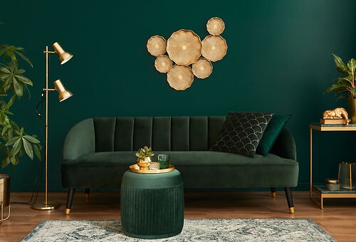 Goldene Stehlampe vor grünem Hintergrund