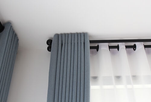 Dunkelblaue Gardine hängend an einer Gardinenstange