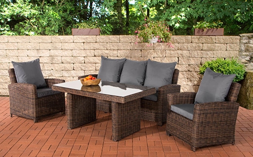 Rattanlounge mit Stühlen, Bank und Tisch auf Terasse